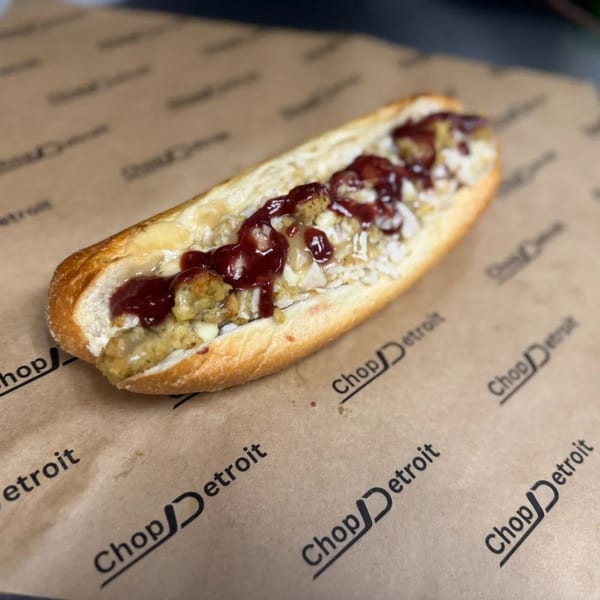 A Chop Detroit sandwich filled with stuffing, gravy, and cranberry sauce on branded paper.