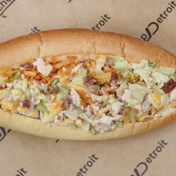 Chop Detroit sandwich with chicken, lettuce, cheese, bacon, and crispy toppings on a hoagie roll.