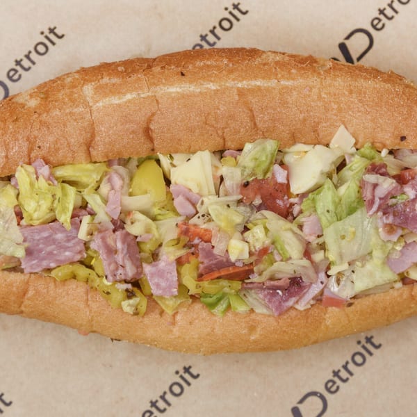 A close-up of a Detroit-style sub sandwich filled with various meats, cheese, and lettuce.